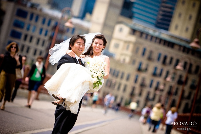 groom holding bride on stone arch bride