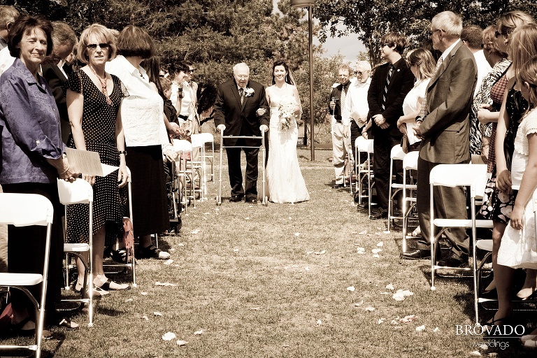 bride being walked down the aisle by her father