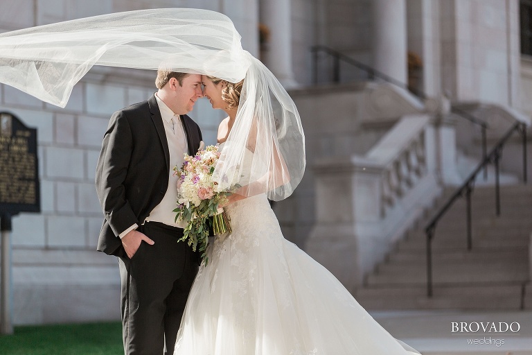 Bride and groom post in front of historic st paul building