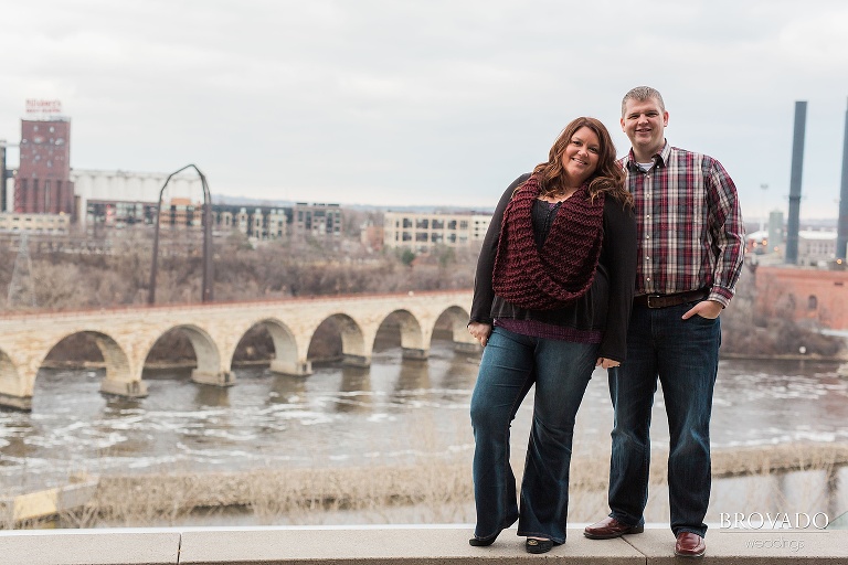 Engagement pose in front of stone arch bridge