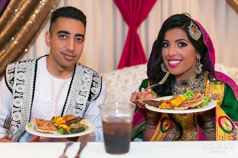 Bride and groom eating indian dinner at wedding reception