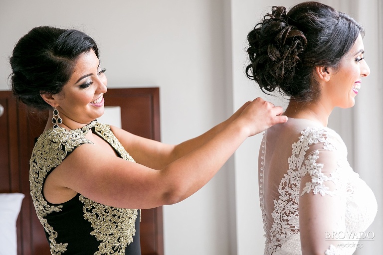 Bride getting ready with assistance from bridesmaid