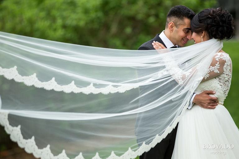 Dramatic veil photograph of bride and groom