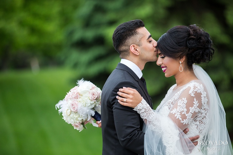 Groom kisses bride on her head on wedding day