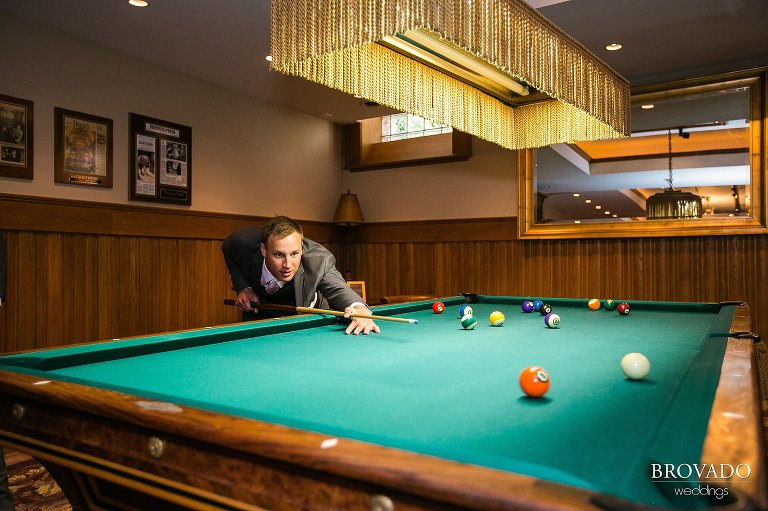 Groom playing pool in the Van Dusen Mansion