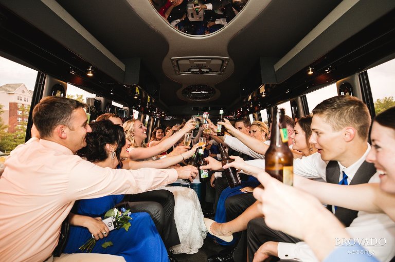 Wedding party toasting on party bus