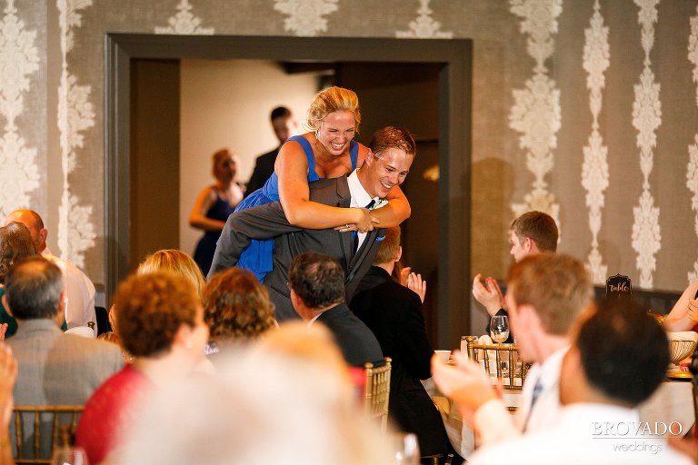 Groomsman carrying bridesmaid for grand entrance