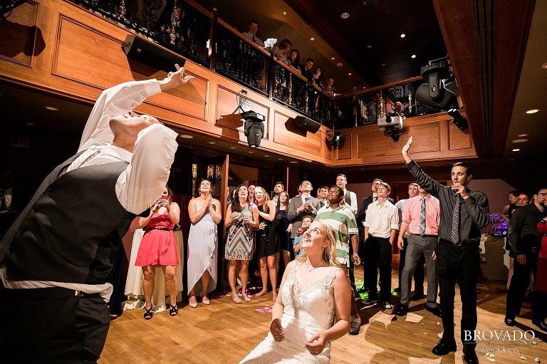 Groom throwing garter over shoulder