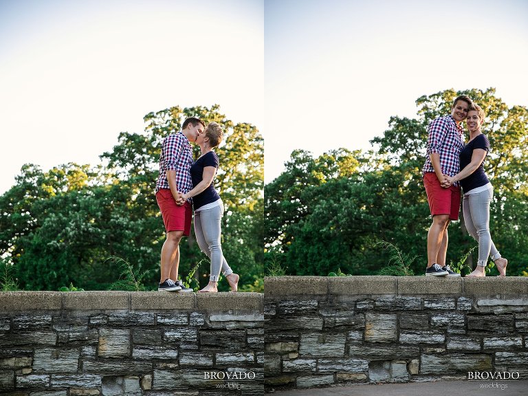 Anna and Cil kissing on a rock wall