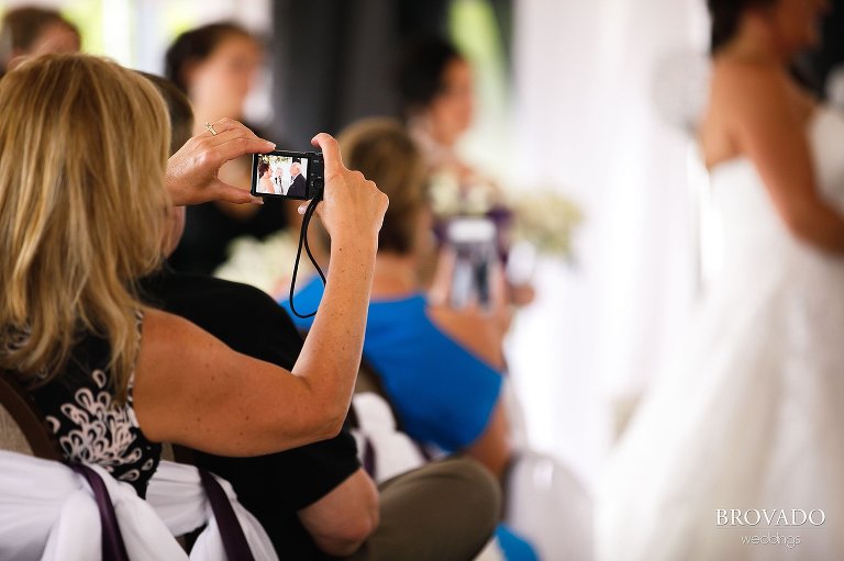 Guest taking a digital photo of wedding ceremony