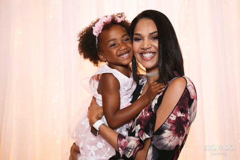 Wedding guests posing in front of pink bright backdrop
