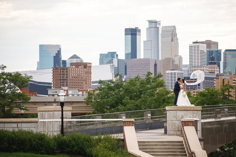 Bride and groom on university of minnesota campus in front of minneapolis skyline