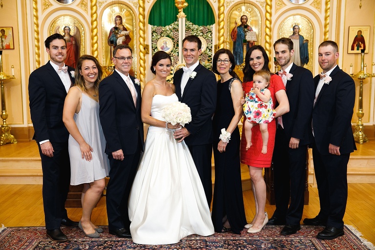 Bride and groom posing with family