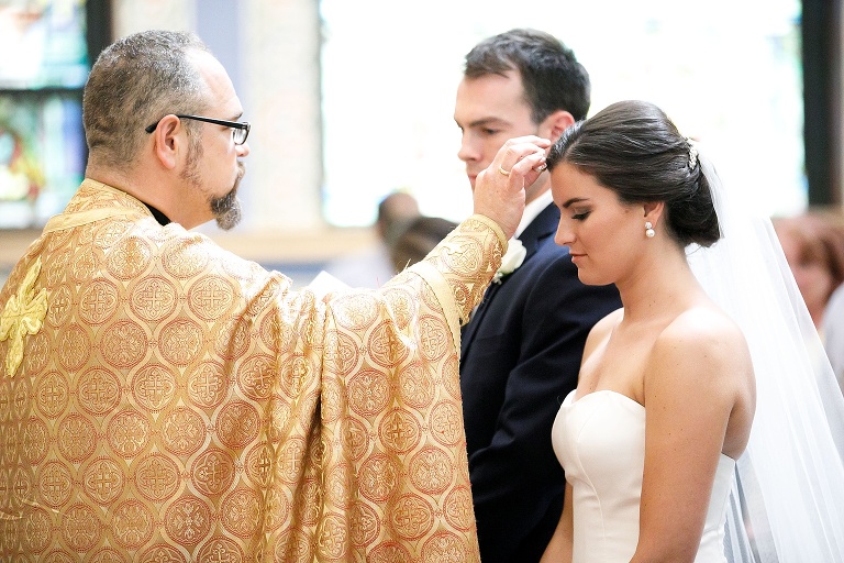 Priest blessing Julianne during ceremony