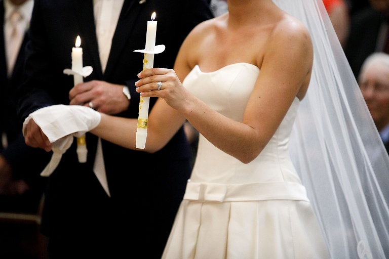 Bride and groom holding prayer candles
