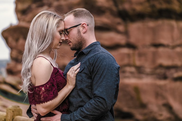 Couple posing in front of colorado red rocks
