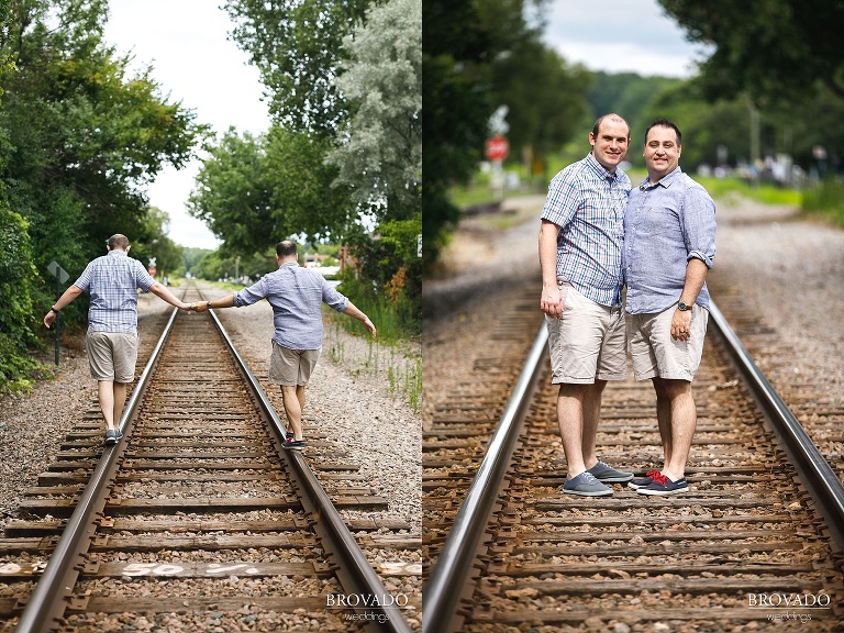 Zach and Tom holding hands on railroad tracks