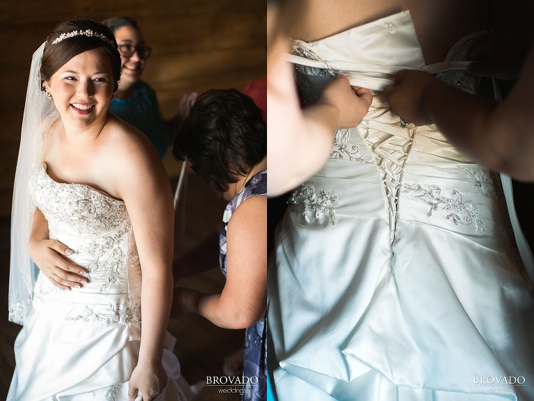 Bridesmaids lacing up back of wedding dress