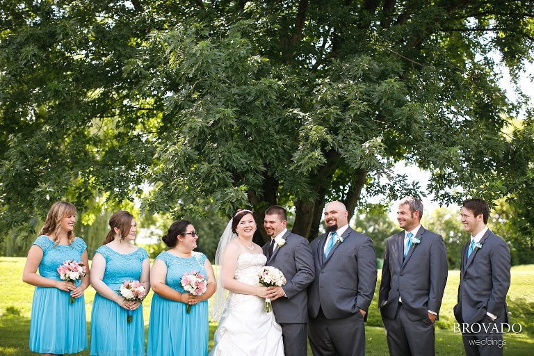 Wedding party in turquoise posing under a tree