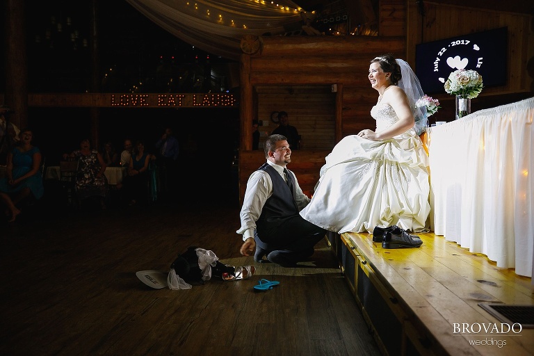 Groom pulling garter off of Elizabeth