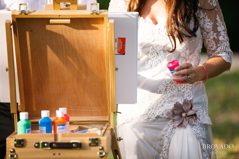 Nova holding paint in her wedding dress