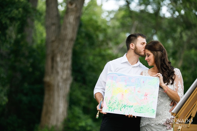 Married couple holding their painting in wedding attire