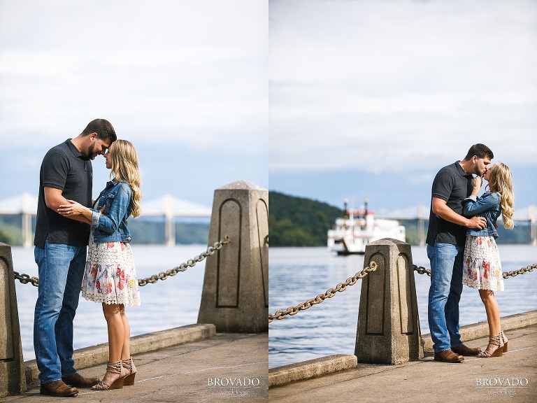 Engaged couple kissing in front of boat on the st croix