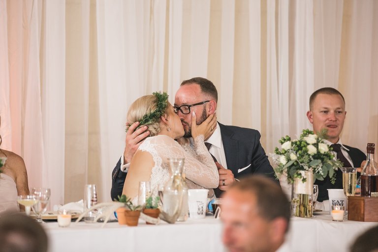 Bride and groom kissing at wedding reception