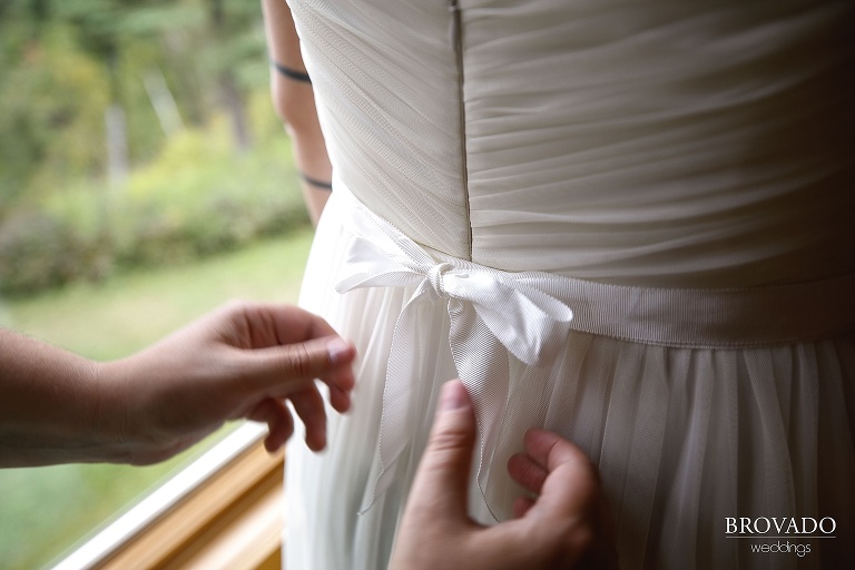 Karen's wedding dress being tied in a bow