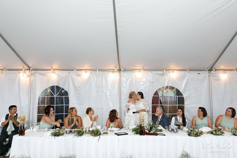 Brides kissing at head table