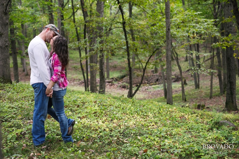 Cute engagement of couple kissing in the woods