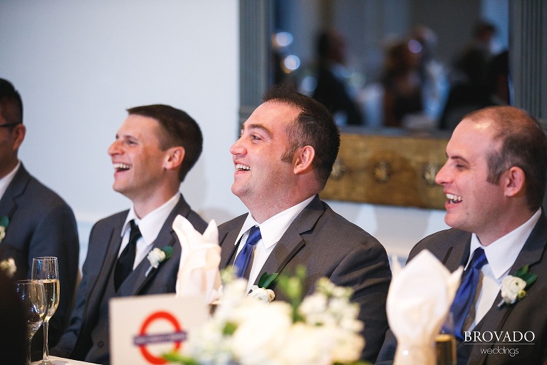 Grooms laughing during toasts at Wayzata Country Club