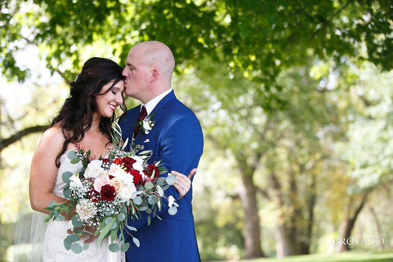 Derek kissing his bride on the forehead