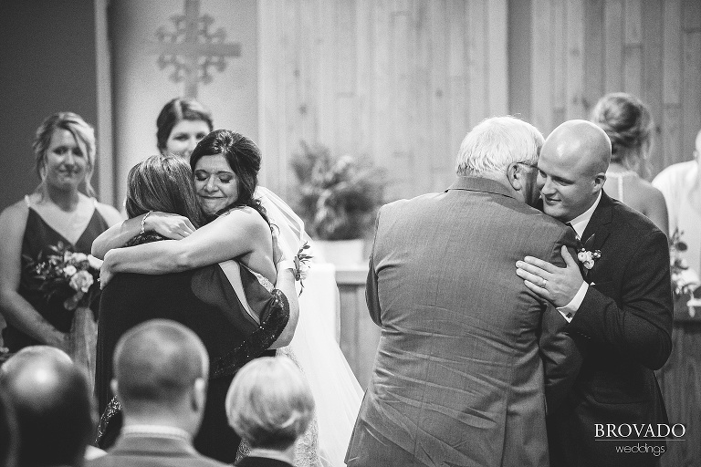 Brenna and Derek hugging their parents in black and white