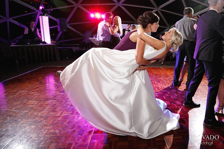 Bride's best friend dancing with and dipping her