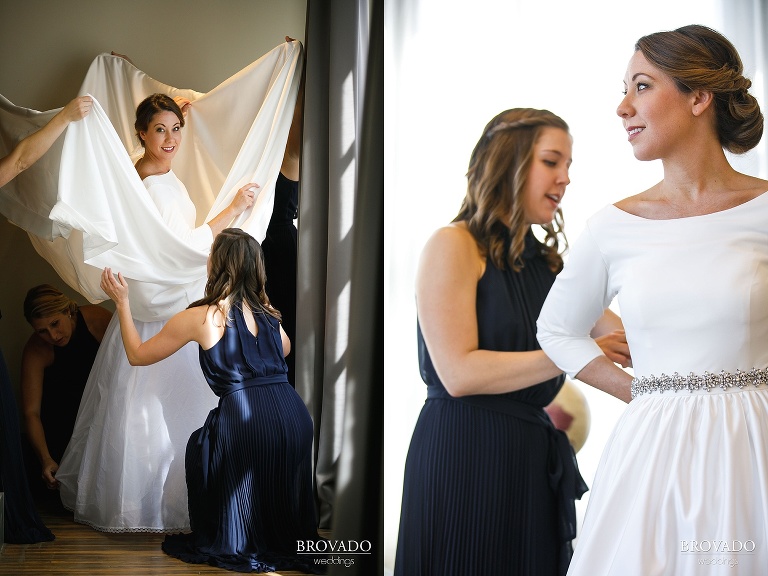 Bridesmaids helping Hannah put on her wedding dress