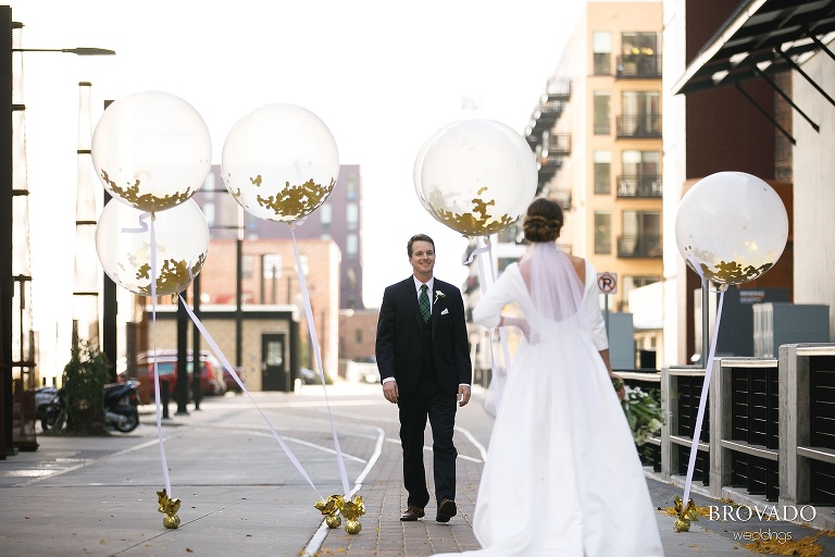 Hannah and Jason's first look with gold and white balloons