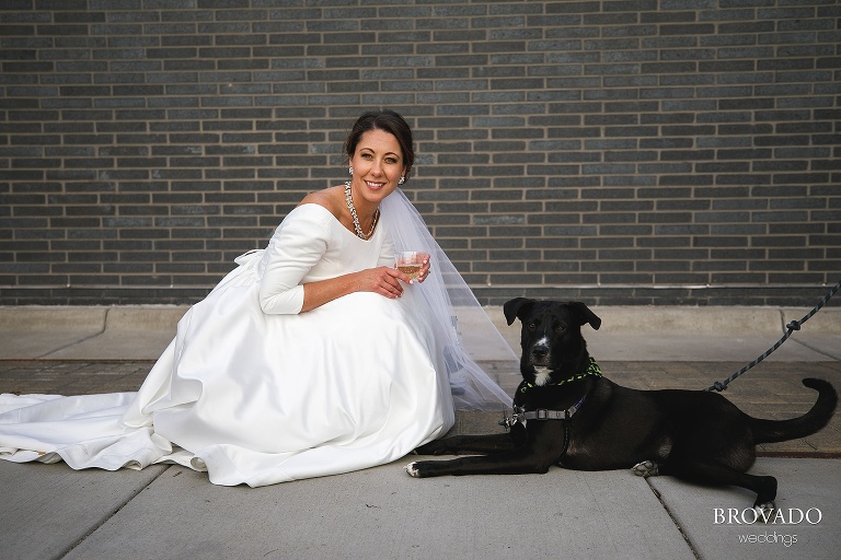 Bride posing with a dog and champagne