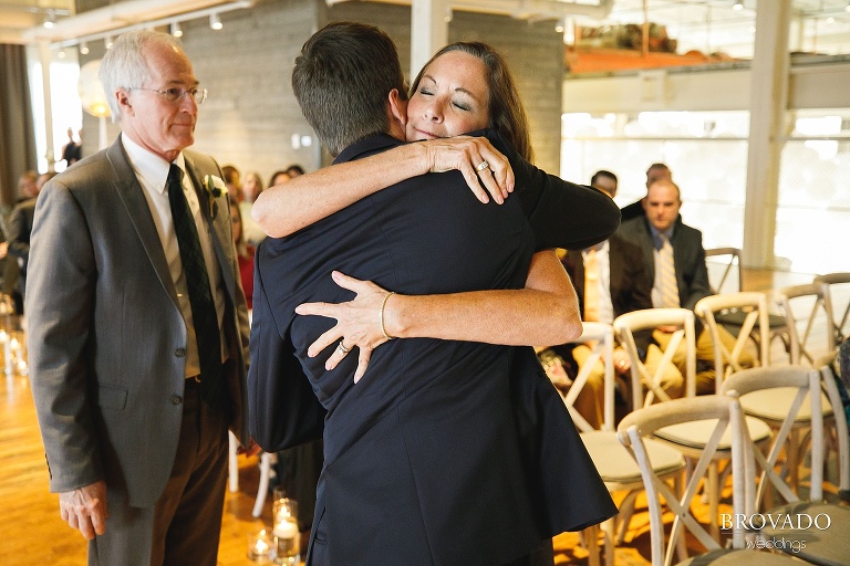 Jason's mother hugging him at front of the aisle
