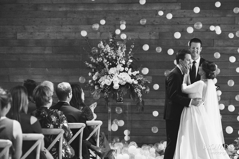 Hannah holding her husband's face after their first kiss