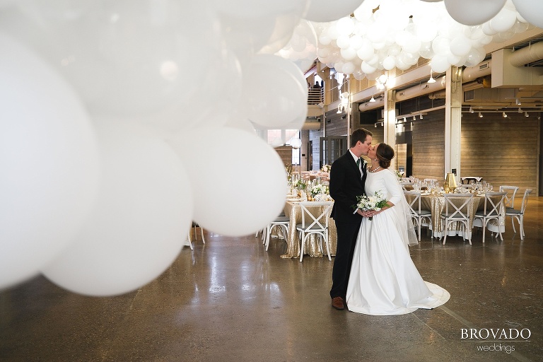 Hannah & Jason kissing among balloon installation from girl friday creative