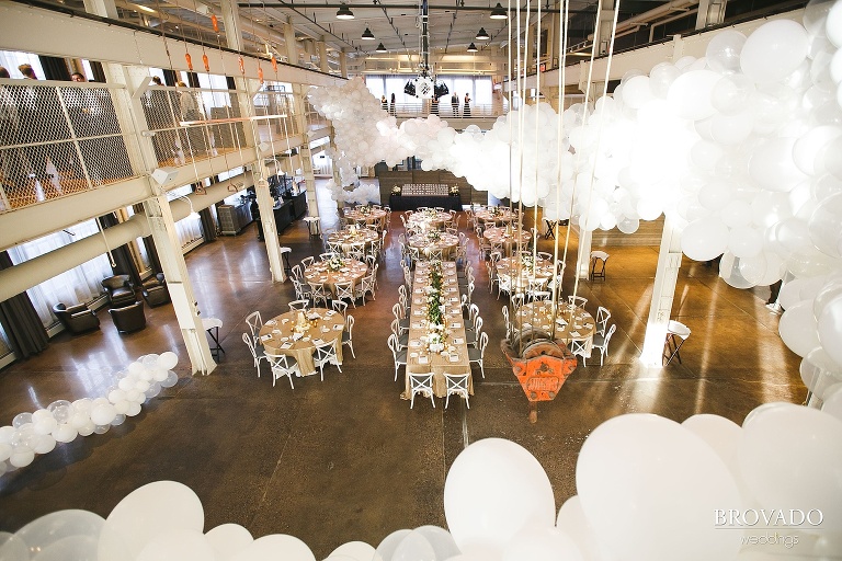 Machine shop wedding reception setup with white balloon installation by girl friday