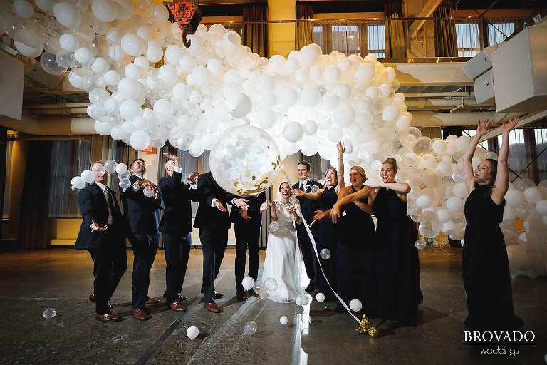 Wedding party throwing girl friday balloons in the air