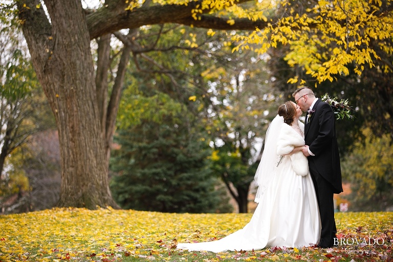 Megan and Ben kissing on fall leaves