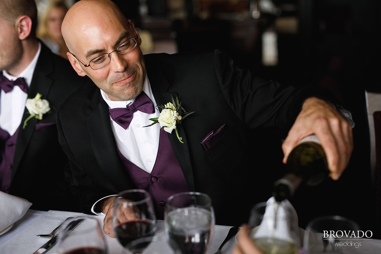 Wedding party member in purple pouring wine