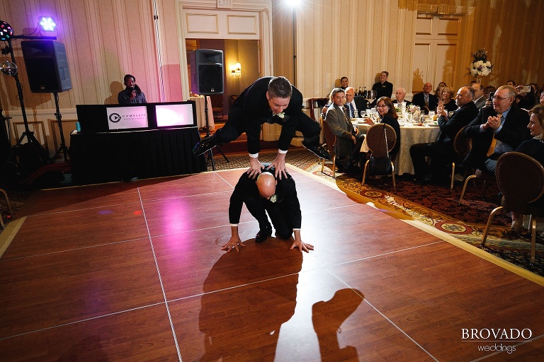 Groomsmen playing leapfrog during grand entrance