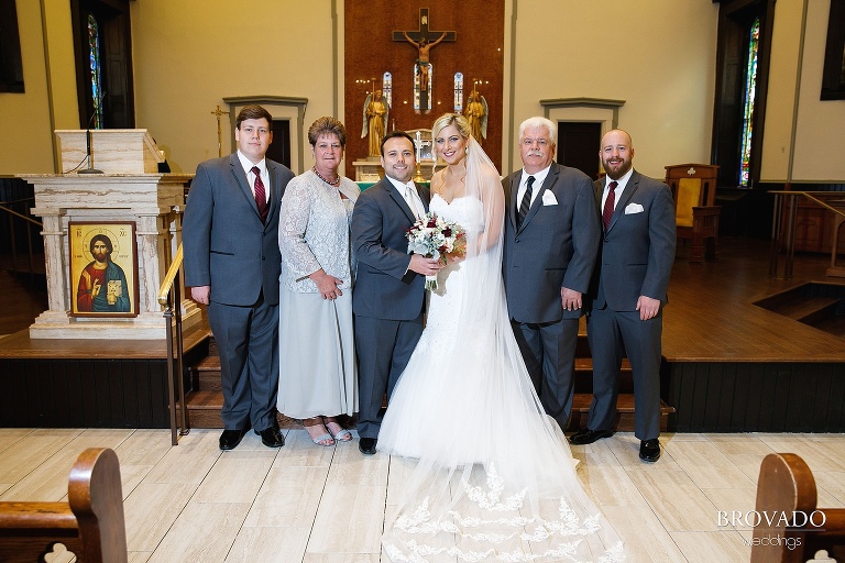 Rachel and Joe posing with their family at the front of Minneapolis church