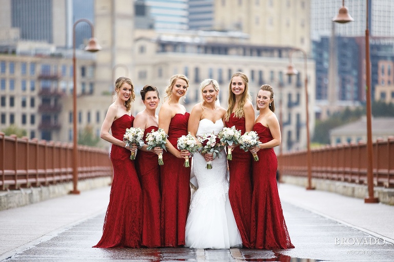 Rachel and her bridesmaids in red dresses on the stone arch bridge
