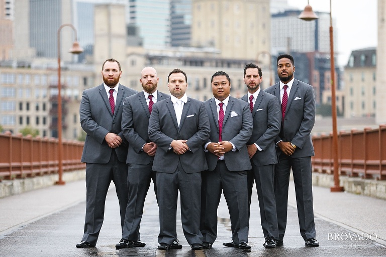 Joe and his groomsmen in a serious pose on the stone arch bridge