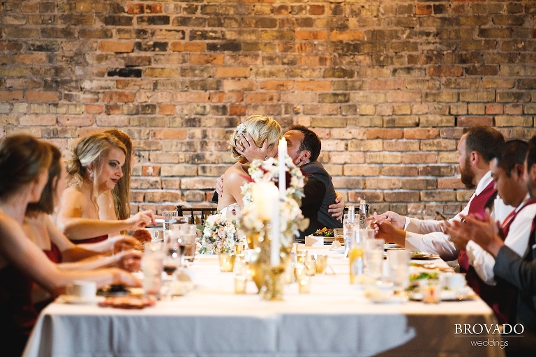 Rachel and Joe kissing at the head table